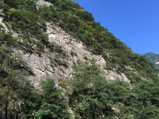青山绿树间的陡峭山壁