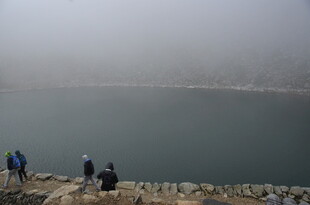 雾中湖畔的游人身影