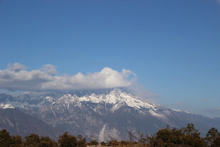 雪山远景 蓝天绿树相衬