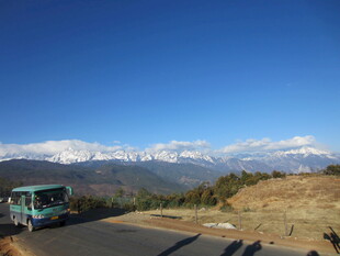公路旁的雪山与行驶车辆