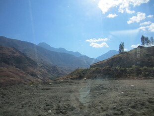 山间开阔地与远处山峰景色