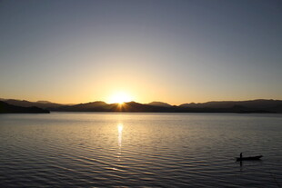 夕阳下静谧湖面小船景象