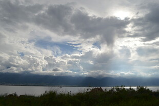 云隙间洒下阳光的湖畔风景