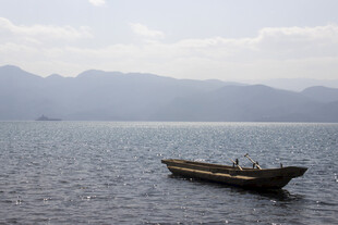 孤舟泛于宁静湖山之间