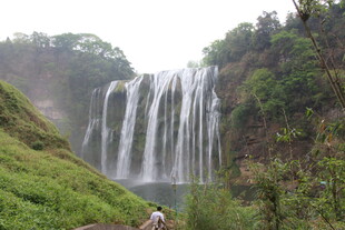 山间瀑布下的徒步者