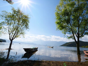 湖畔小船与绿树蓝天美景