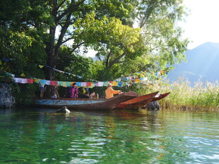 河畔小船与彩色经幡美景