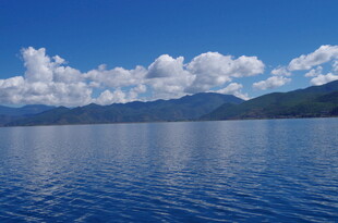 宁静湖面与远方山峦蓝天