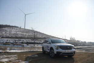 雪地旁的汽车与风力发电机