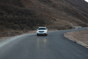 山间公路上行驶的白色汽车
