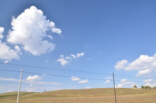 蓝天旷野间的电线与白云