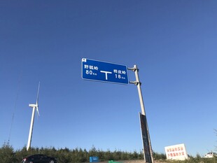 道路指示牌与远处风车景观