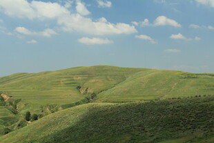 翠绿山丘与蓝天白云美景