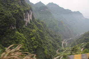 山间公路蜿蜒于翠绿山峦