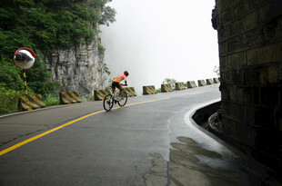 骑行者穿行于山间公路
