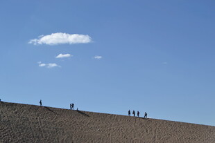 蓝天旷野上的漫步人群