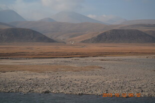 荒凉河谷与远处山峦景观