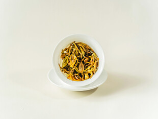 白色瓷碗中的金黄色茶叶