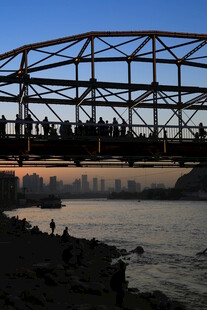 夕阳下桥上人群与河畔风景