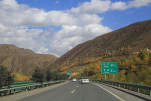 公路穿行于山峦蓝天白云间