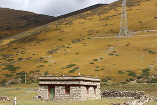 山间石屋与远处高塔