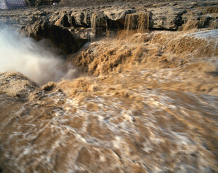 湍急河水冲击岸边岩石