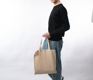 手持米色手提袋的时尚人士