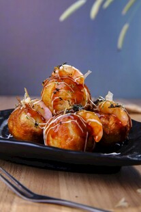 美味烤虾球摆放在黑盘上