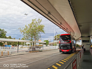 公交站台下的红色巴士
