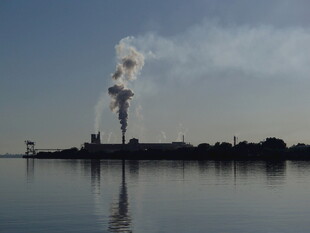 湖畔工厂烟囱冒烟景象