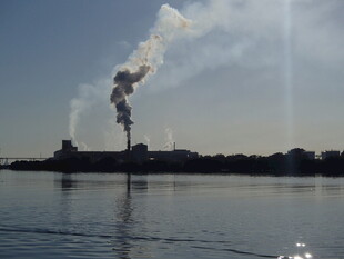 湖边工厂烟囱排放烟雾