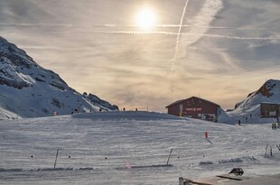 冬日雪山下的红顶小屋