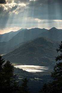 山间晨光洒向静谧湖泊