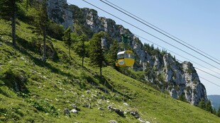 山间缆车穿梭于翠绿峭壁