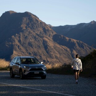 公路漫步的女子与远方汽车