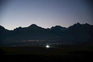 夜幕下的山峦与远方灯火