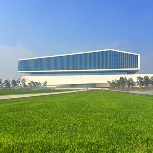 现代建筑旁的翠绿田野