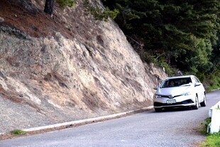 山间公路上行驶的白色汽车