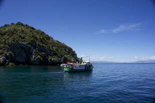 海上船只停靠绿意岛屿旁