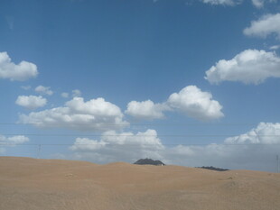 蓝天黄沙间的广袤沙漠景观