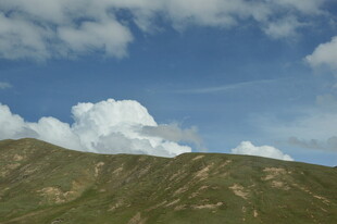蓝天白云下的翠绿山峦