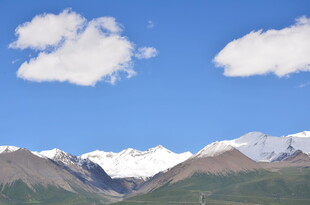 蓝天白云下的壮丽雪山