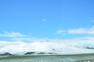 蓝天覆雪山 广袤平原景