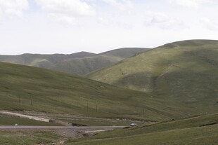 山间公路蜿蜒于翠绿山坡