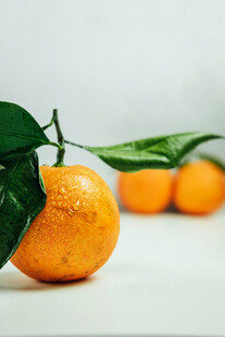 新鲜橘子带叶摆放在桌面