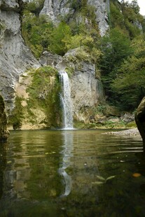 山间瀑布下的静谧湖水