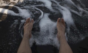 双脚浸于海浪泡沫之中