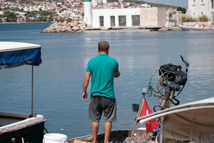男子于码头眺望远方海景