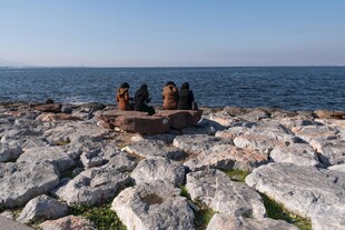 海边岩石上休憩的几个人