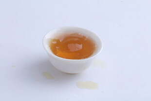 白色小杯中的琥珀色饮品